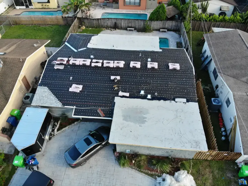 Aerial view of a South Florida house partway through a roof replacement with the old covering stripped off one side