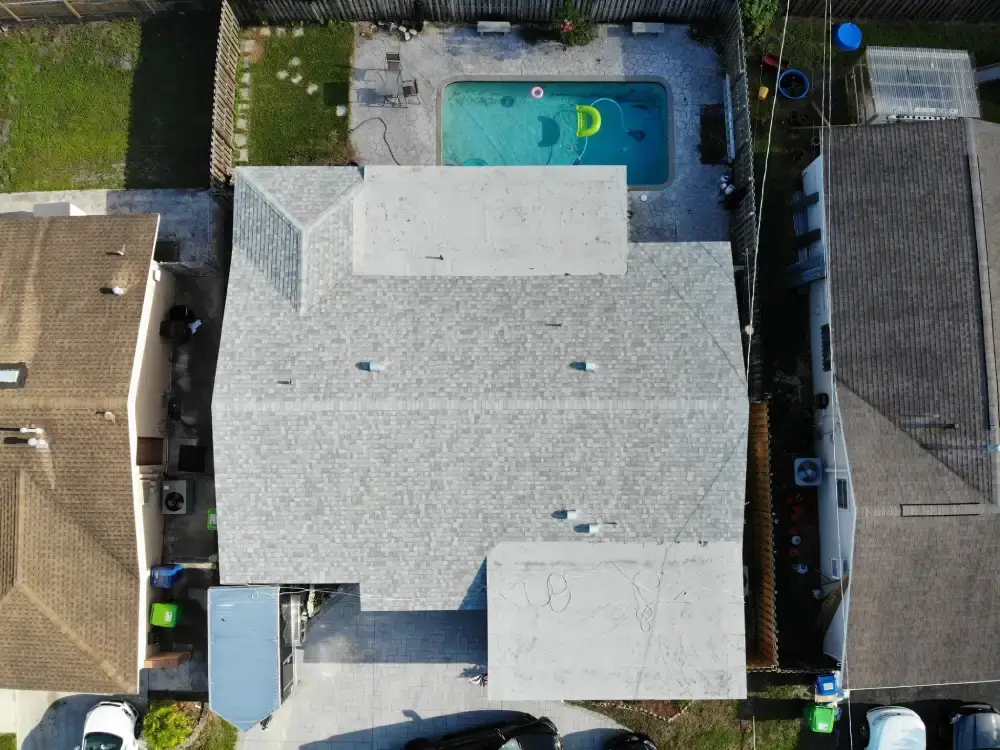 Aerial view of a finished South Florida roof with the pool screen enclosure alongside it