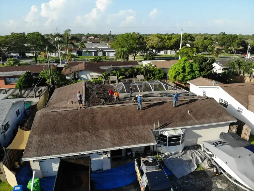 Aerial view of a South Florida roof during tear-off with the crew working across the slopes