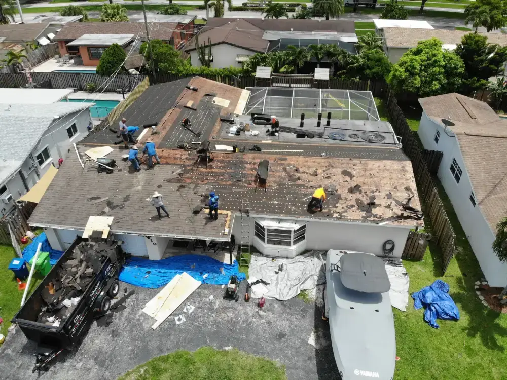Aerial view of a re-roof in progress with tarps laid out to protect the driveway and landscaping