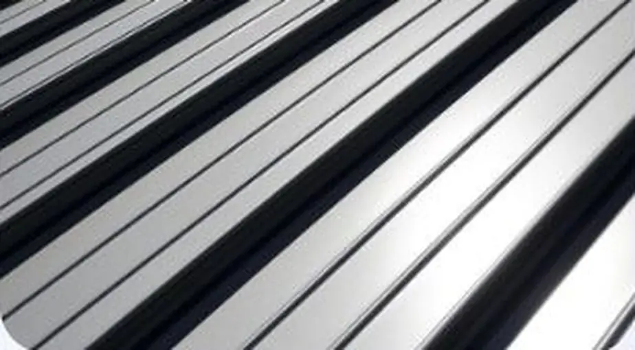 Close-up of silver standing seam metal roof panels showing the raised interlocking ribs